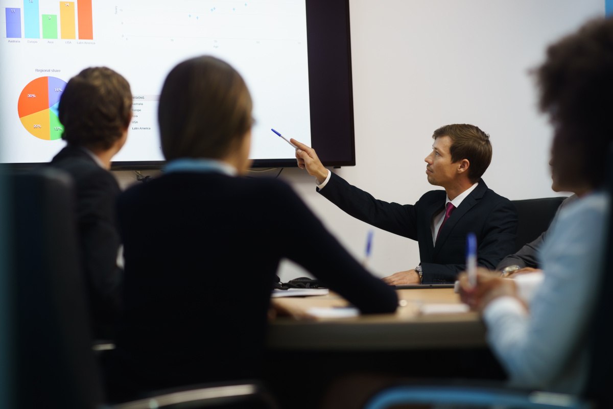 Business people looking at graphs on a projector screen