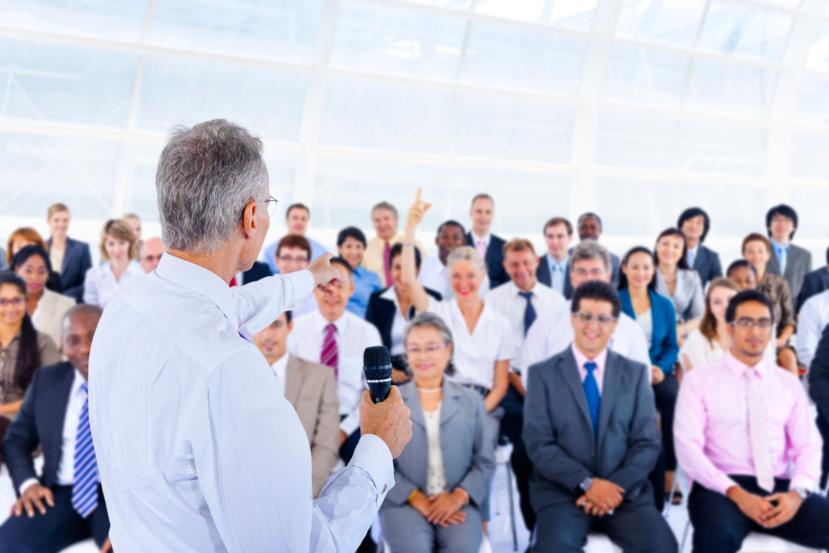 Business people listening to a speaker at a convention