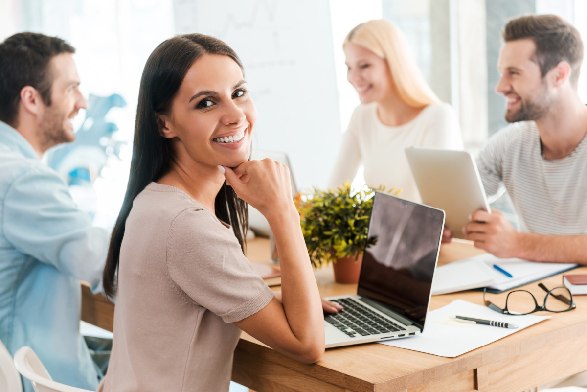 A woman smiling while working with her colleagues